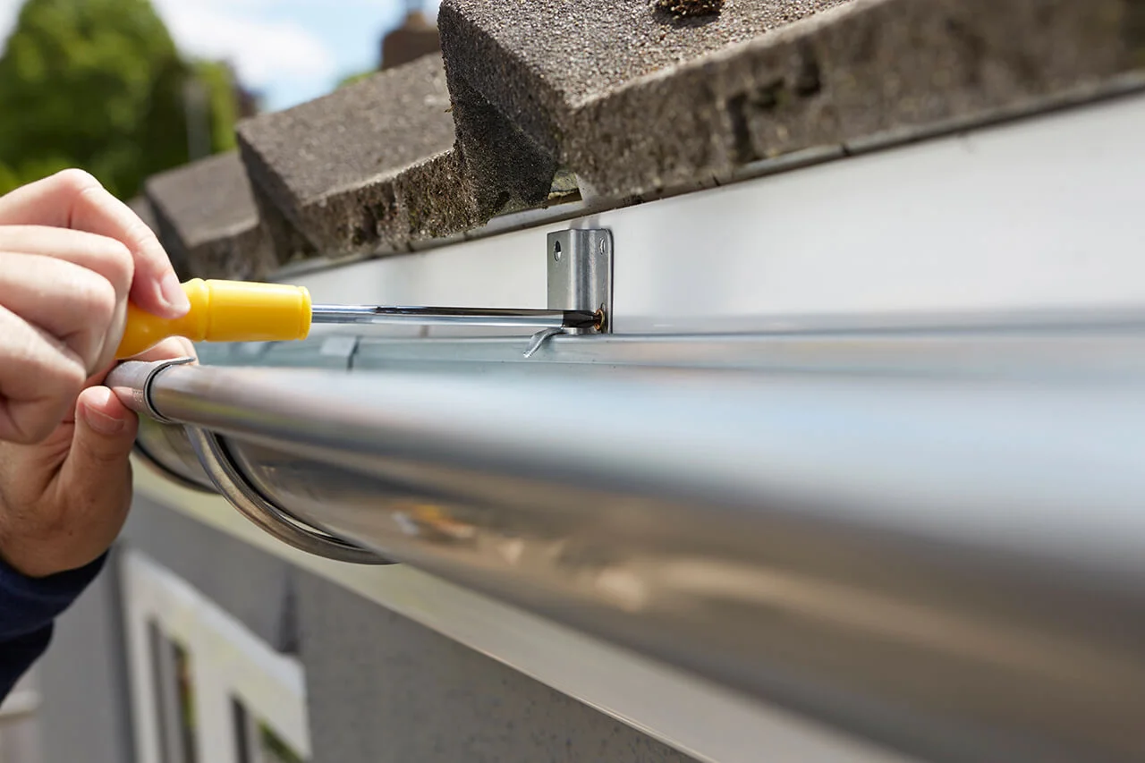 Gutter repair technician fixing sagging gutter
